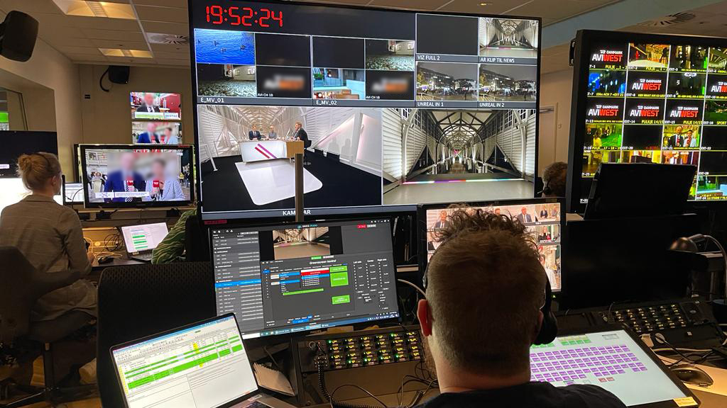 Man sitting in front of multiple screen and controlling live broadcast graphics