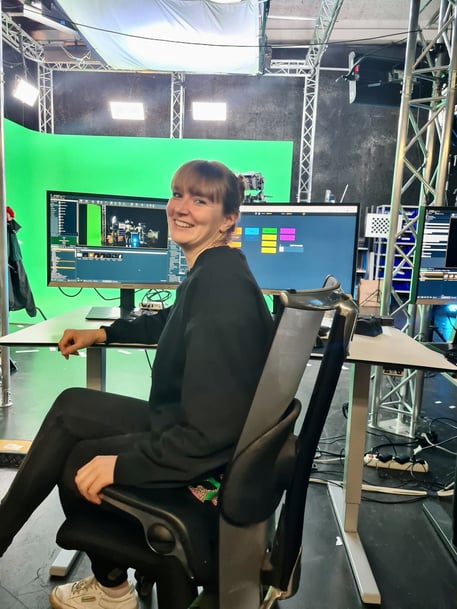 Pixotope Education Program Manager Carina Schoo sitting on the chair in the studio working with Pixotope software