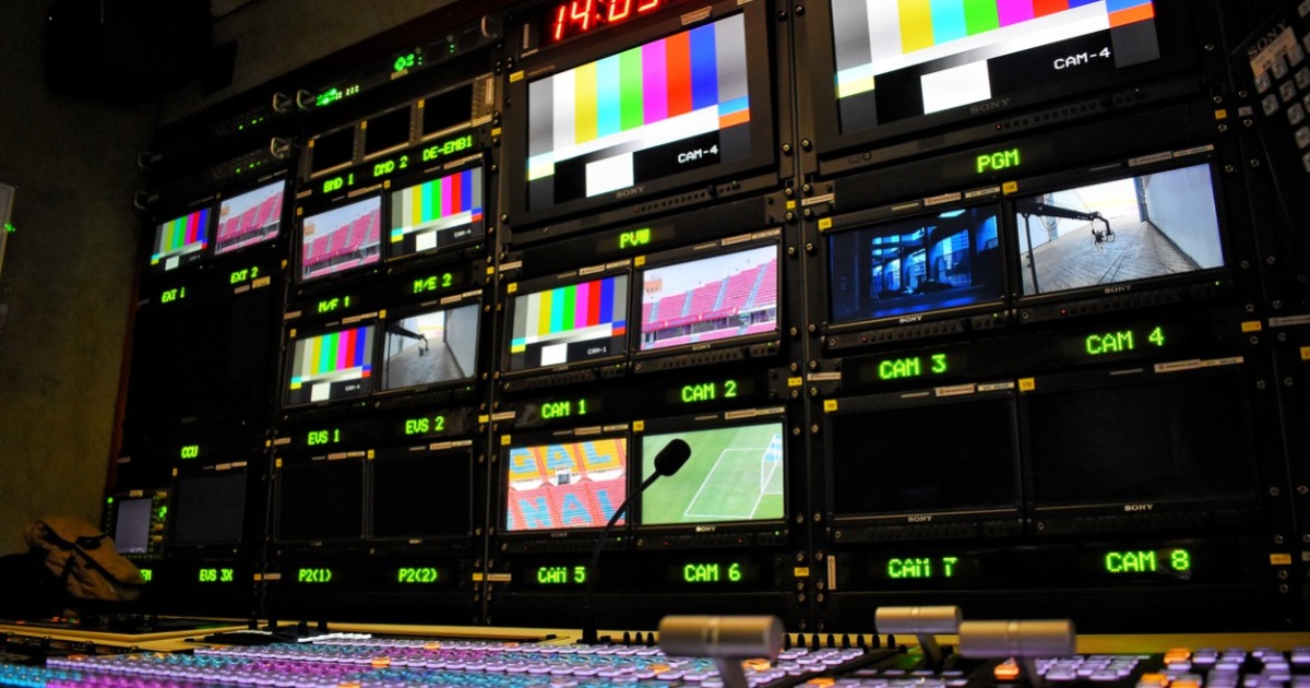 Photo of multiple broadcast control screens showing different content