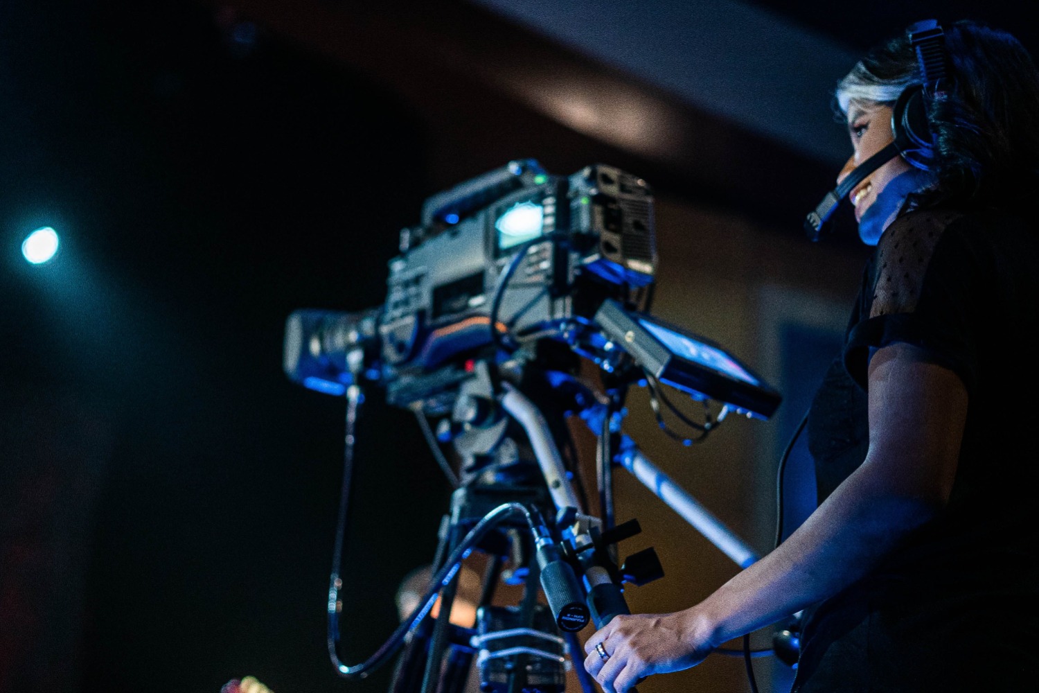 Camera operator with headset and broadcast camera at work