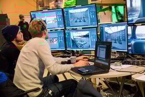 Two men sitting in front of the multiple computer screens working with Pixotope software