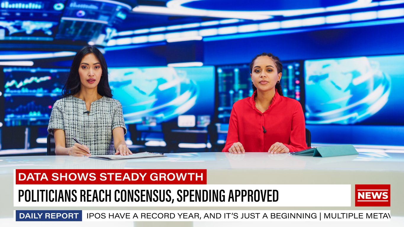 Two female news hosts in a TV studio