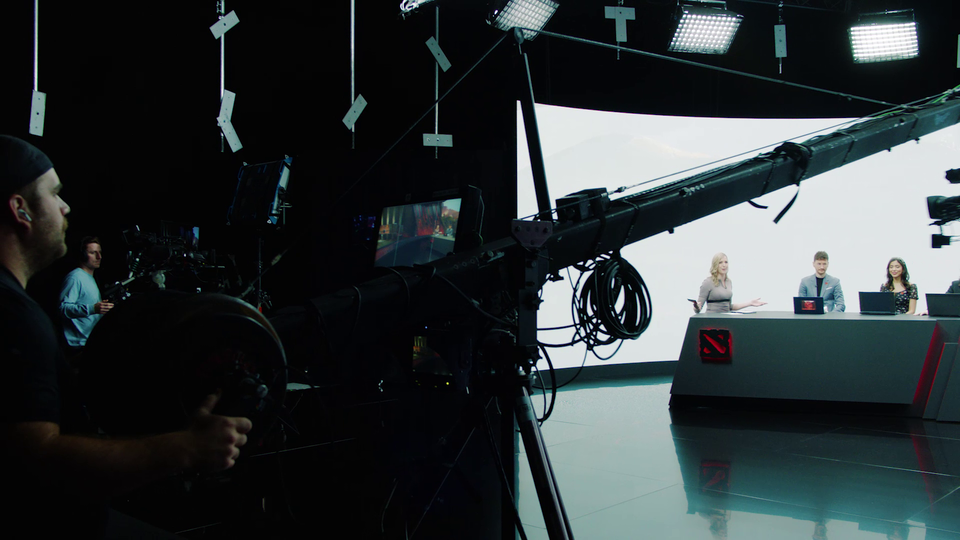 Camera operator pointing camera at the hosts of Dota 2 tournament